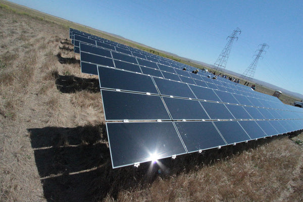 Ground-mount solar farm with co-located battery energy storage beside a substation